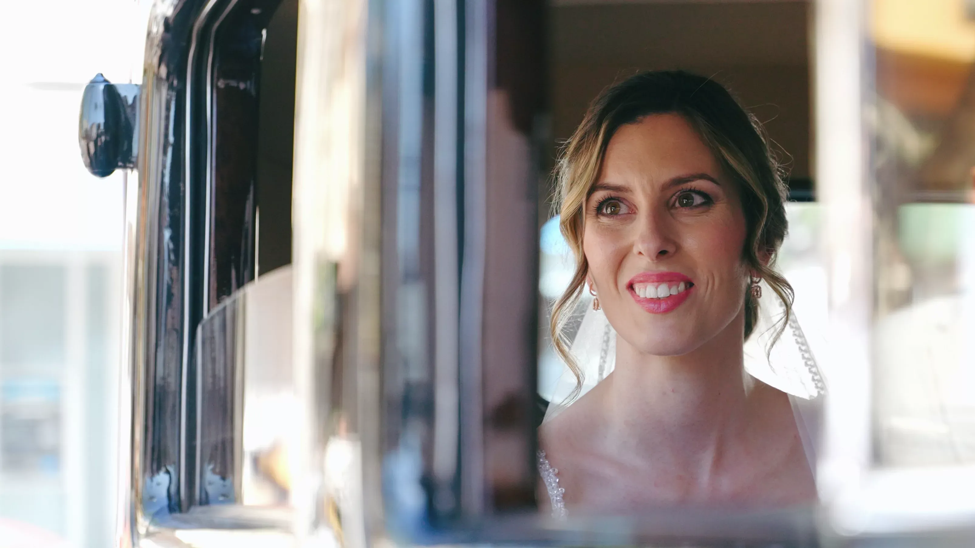 Novia sonriendo desde un coche clásico